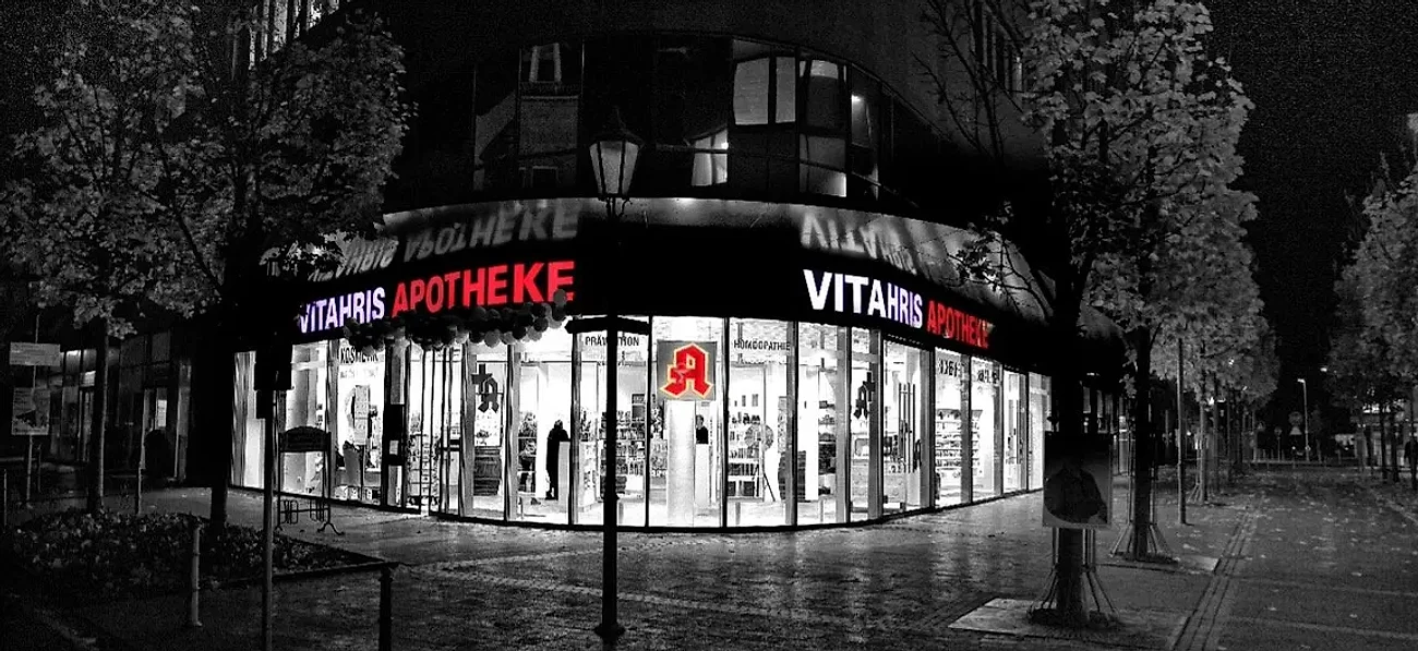 Die Vitahris Apotheke in der Bergstraße bei Nacht, der rote Leuchtschriftzug und das Apotheken-A über dem Eingang